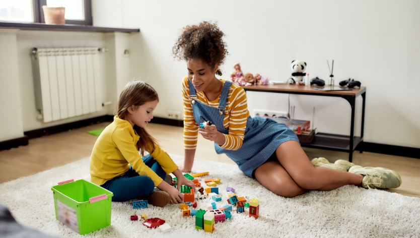 Babysitter and child playing with blocks