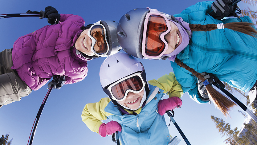 mom and daughters in skiing gear