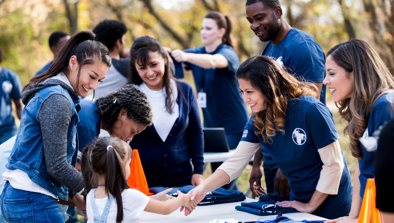 volunteers shaking hands with a kid