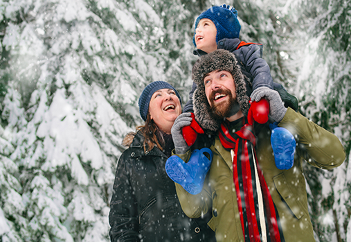 Homme, femme et enfant dehors dans la neige.