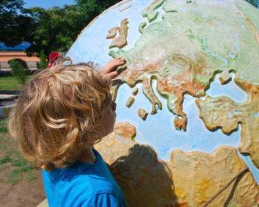 Un enfant qui explore un globe terrestre coloré.