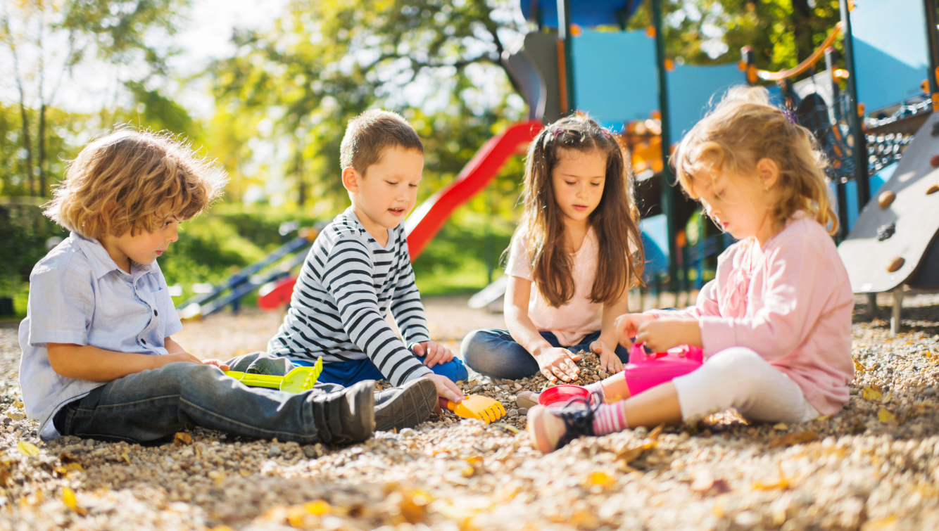 Des enfants qui jouent dans une aire de jeux ensoleillée.