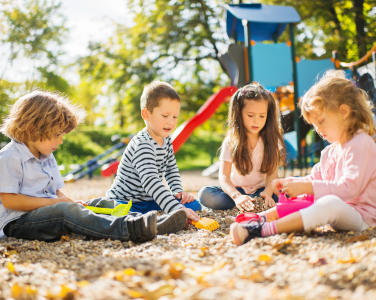 Des enfants qui jouent dans une aire de jeux ensoleillée.