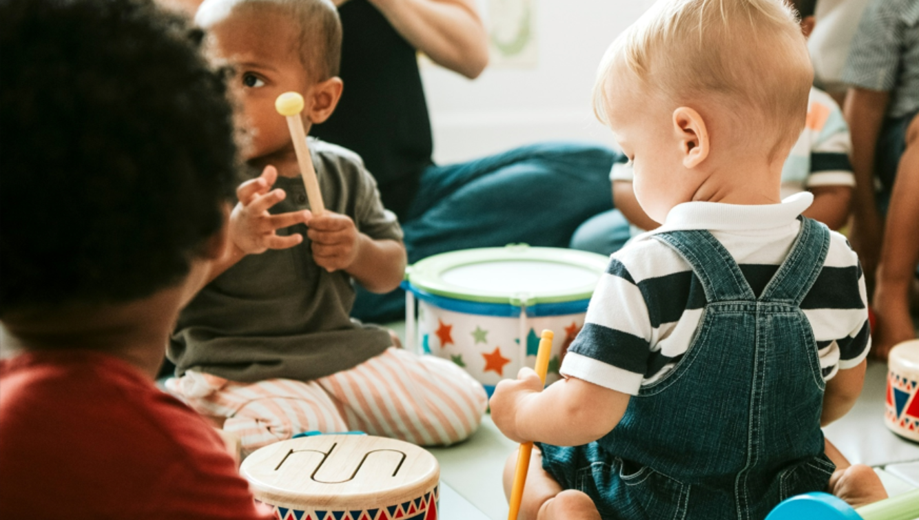 Enfants jouant avec des tambours et des instruments colorés en groupe.