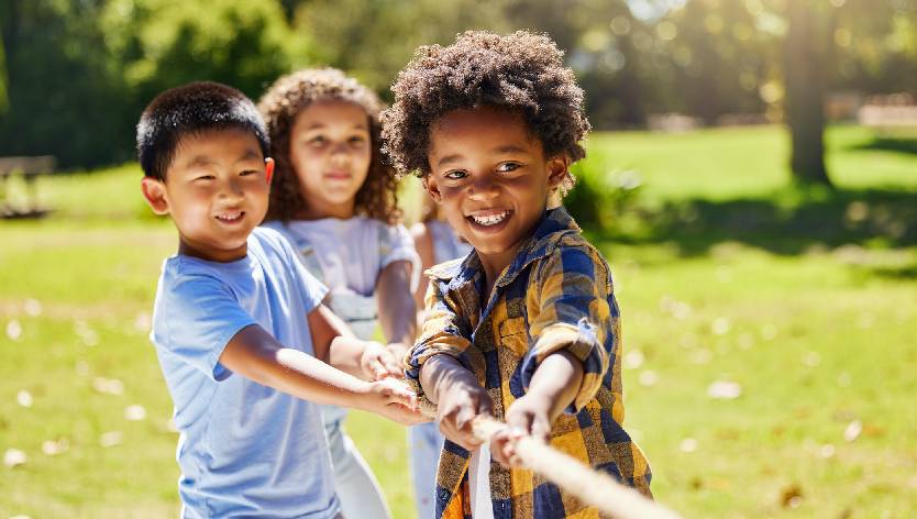 jeunes enfants qui jouent dehors et tirent sur une corde