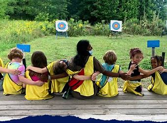 camp d'enfants assis sur un bureau et se tenant par le bras