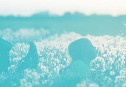 fille soufflant un pissenlit