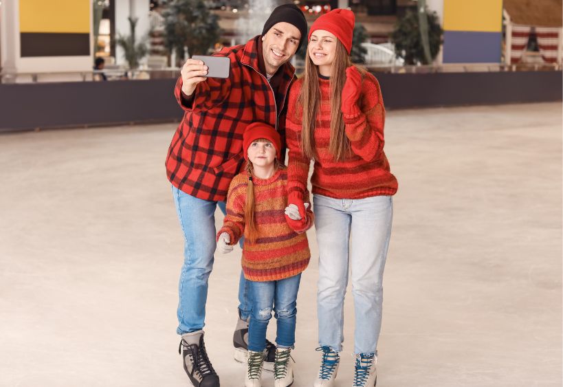 Une famille prend un selfie tout en patinant sur une patinoire