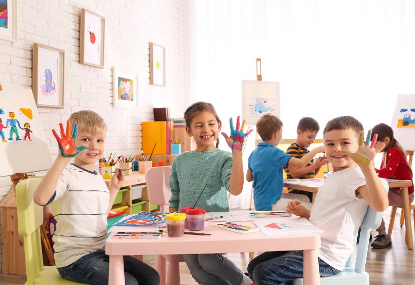 Petits enfants charmants avec des paumes peintes dans une chambre 