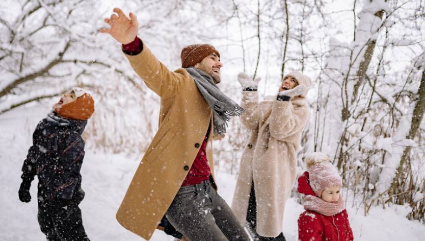 Famille de quatre dehors qui profitent de la neige