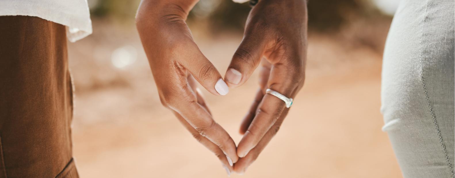 Couple formant un cœur avec leurs mains