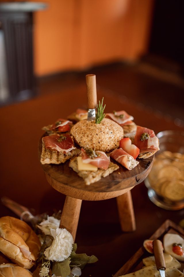 Présentation rustique de fromages et de charcuteries sur une planche en bois, idéale pour les événements