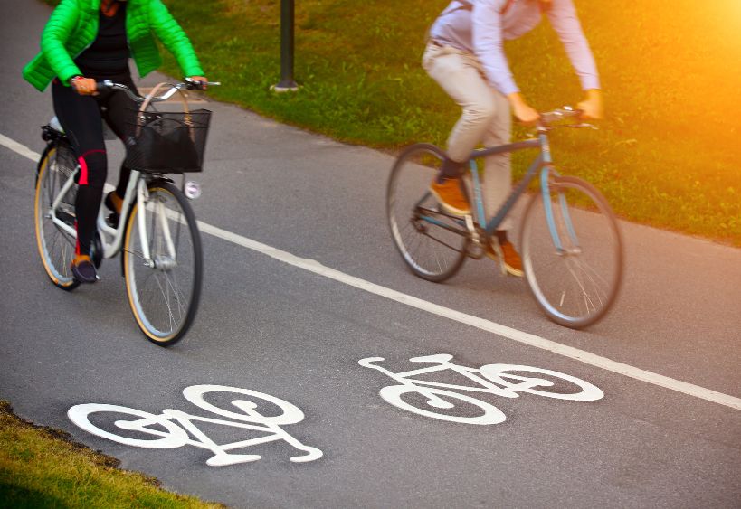 Deux personnes circulent à vélo sur une piste cyclable.