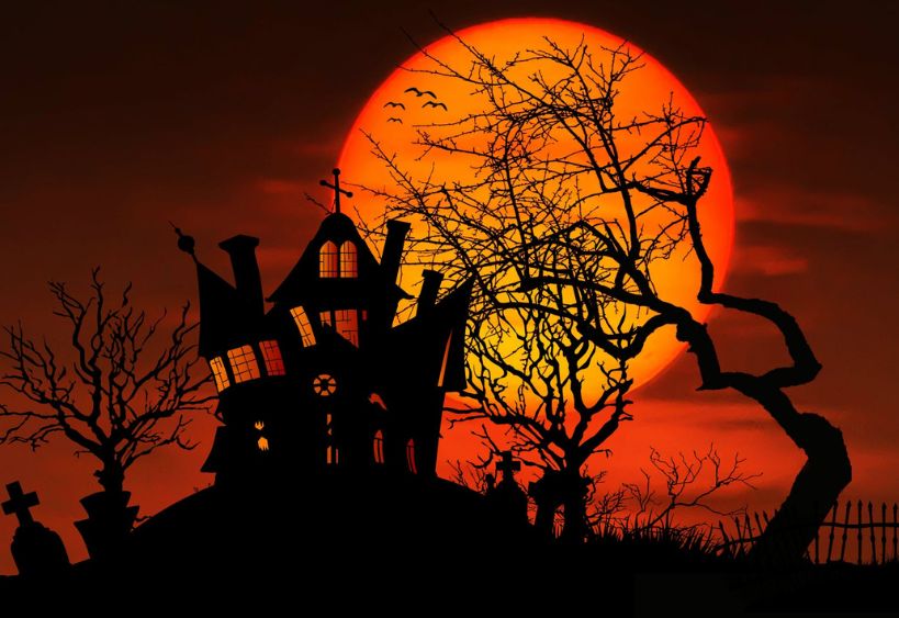 ne maison hantée en silhouette se dresse parmi des arbres dénudés devant une grande pleine lune orange, créant une scène typique d’Halloween.