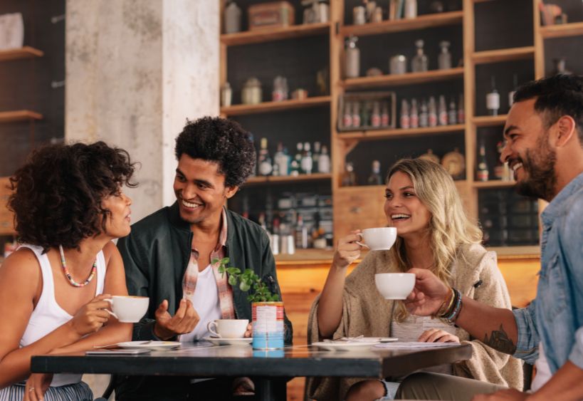 Quatre personnes discutent ensemble dans un café.