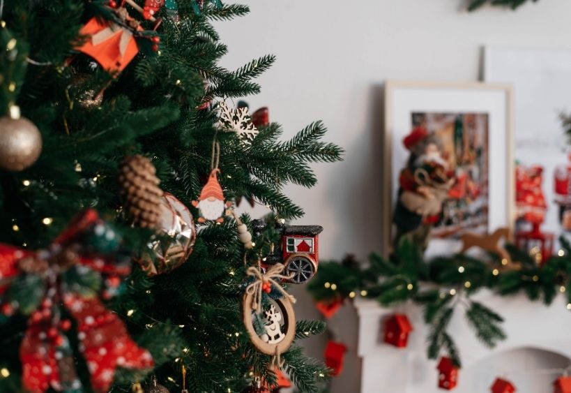 Un sapin de Noël, des cadeaux emballés et une cheminée ornée de bas de noël.