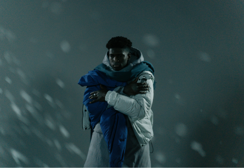 Homme portant un manteau et grelottant lors d’une sombre journée d’hiver