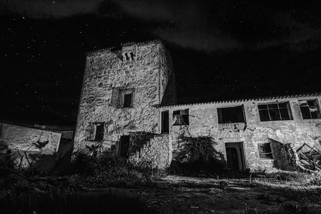 Bâtiment en pierre abandonné, en noir et blanc, la nuit