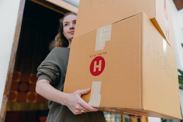 Jeune femme transportant des cartons alors qu'elle déménage