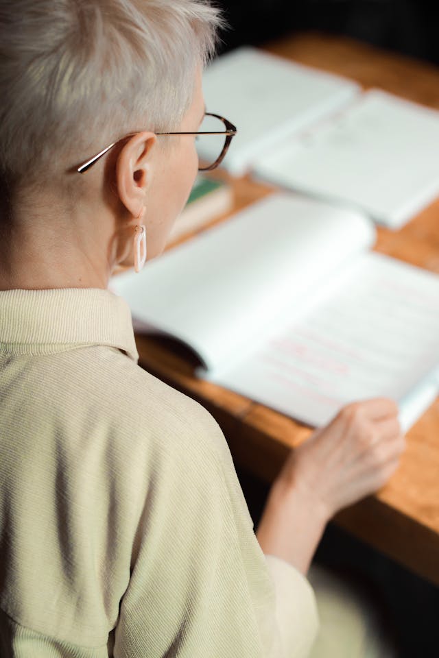 Une femme en train de lire un manuel scolaire