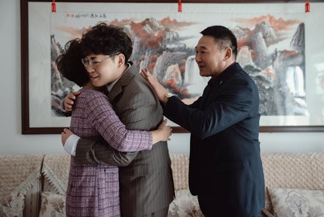 Une famille se serrant tendrement dans les bras à l'intérieur