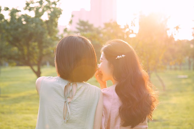 Une femme chuchotant à l'oreille d'une autre femme