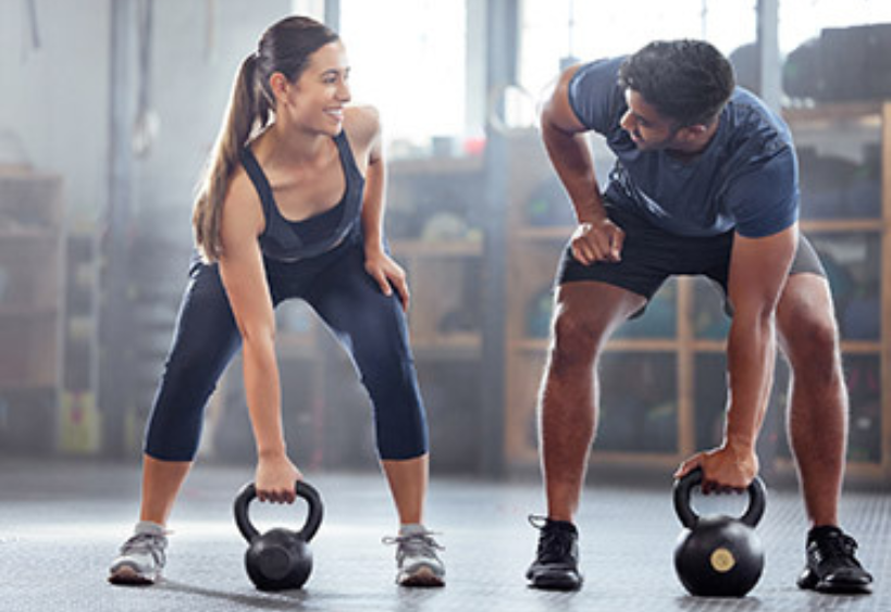 Femme et homme soulevant des kettlebells