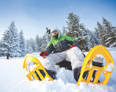 Homme chaussé de raquettes de neige
