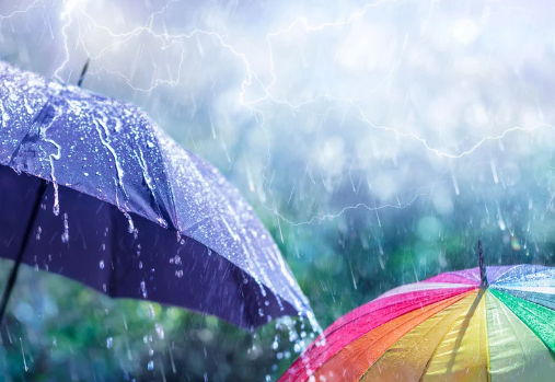 un parapluie bleu et multicolore sous la pluie, avec des éclairs en arrière-plan