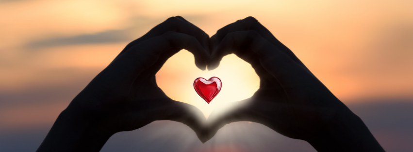 Mains formant le symbole du cœur avec le coucher de soleil en arrière-plan