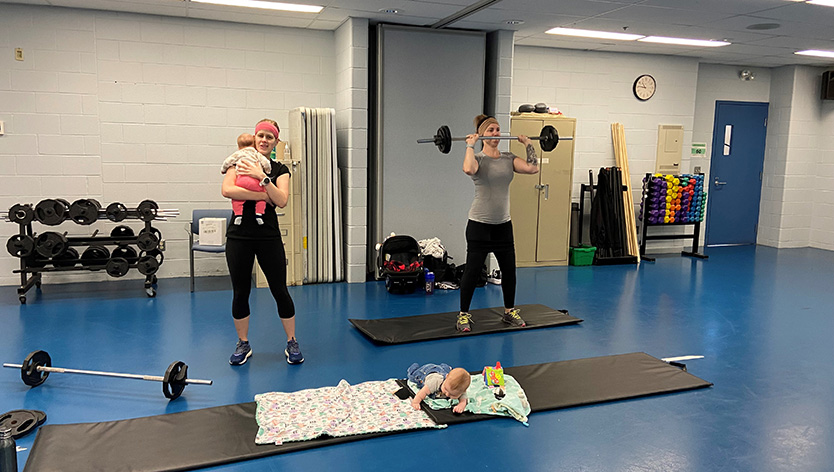 woman with baby working out in gym
