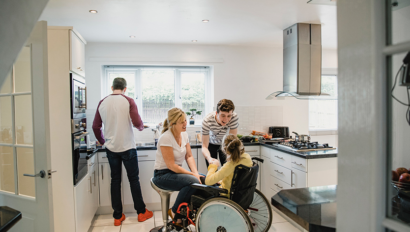 Famille interagissant avec leur fille qui est assise dans un fauteuil roulant