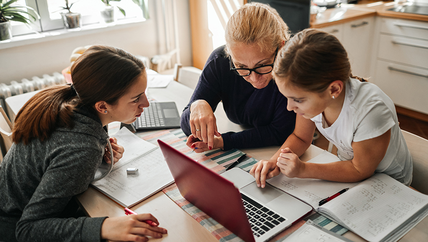 Dame aidant deux enfants à faire leurs devoirs