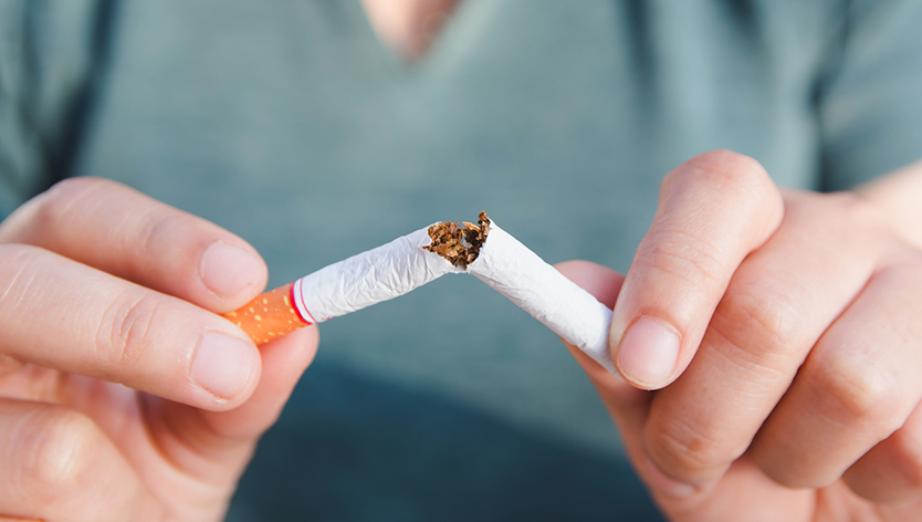 Femme cassant une cigarette en deux