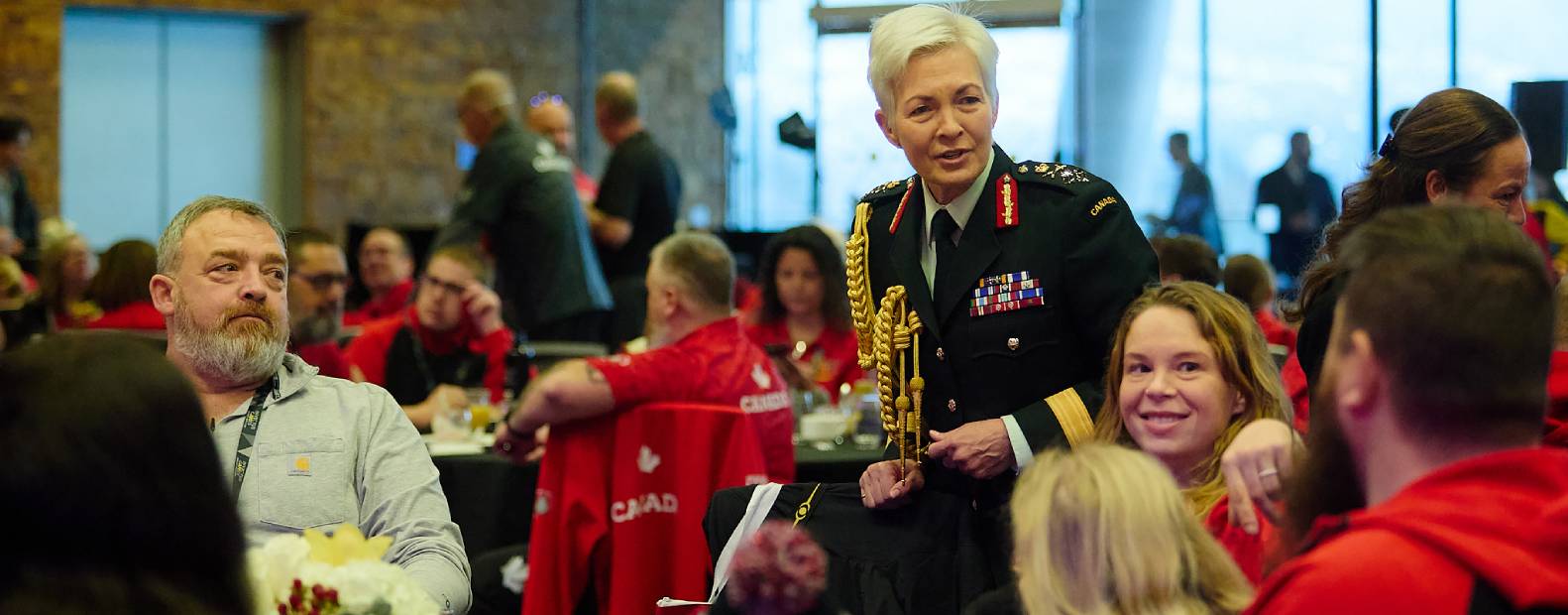 Membre de l'équipe de direction discutant avec des personnes assises à une table