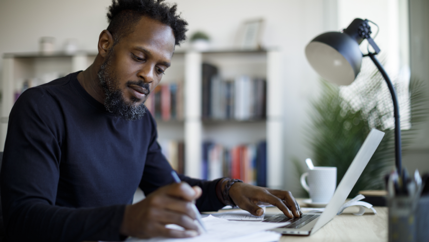 man writing on paper