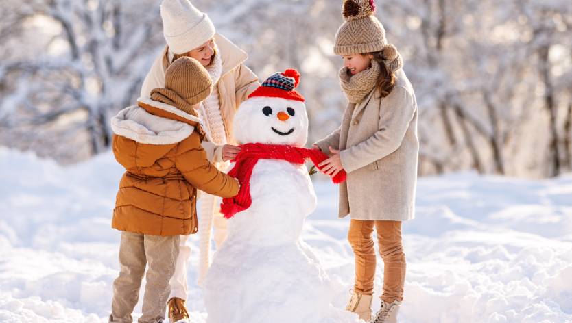 Famille construisant un bonhomme de neige