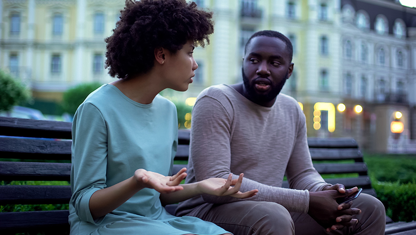 man and women talking on bench