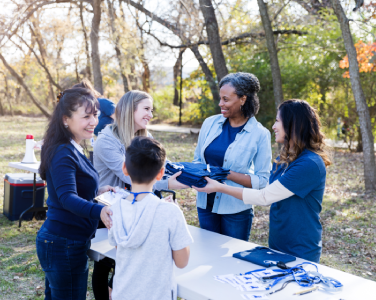 people at a table handing out shirts