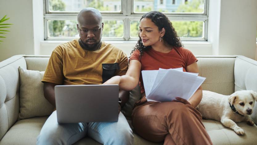 Couple on couch looking at laptop