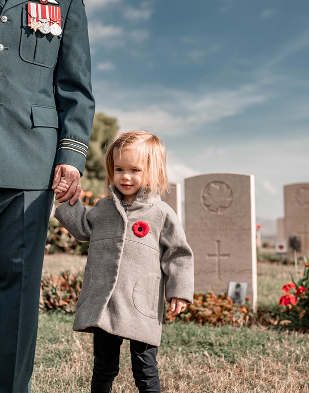 soldier and small child holding hands on remembrance day