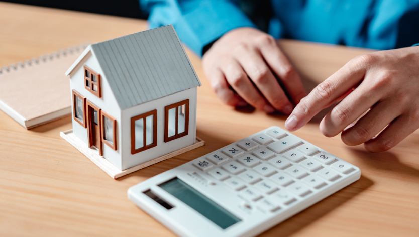 Maquette maison à coté d'une calculatrice