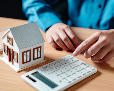 Maquette maison à coté d'une calculatrice
