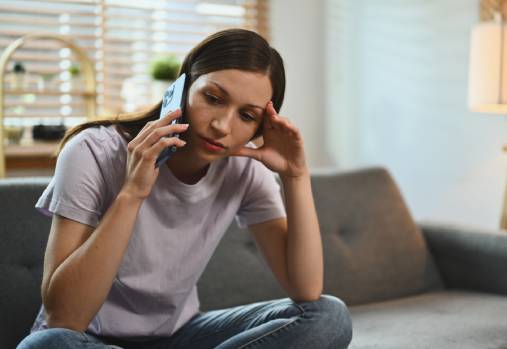 une femme au téléphone, le regard tourné vers le côté