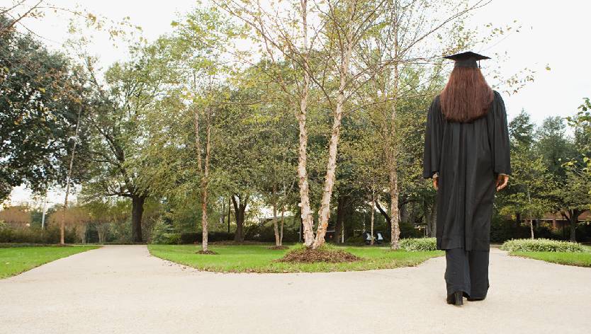 Une femme diplômée marchant sur un chemin