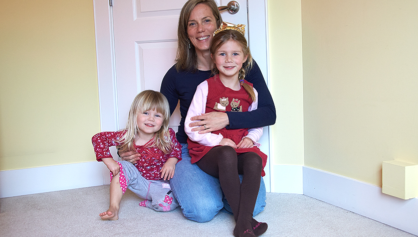 mom holding two girls on lap