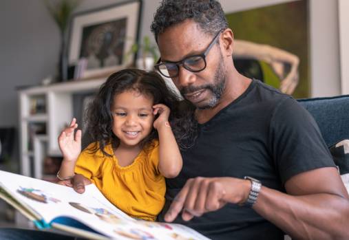 père et enfant regardant un livre